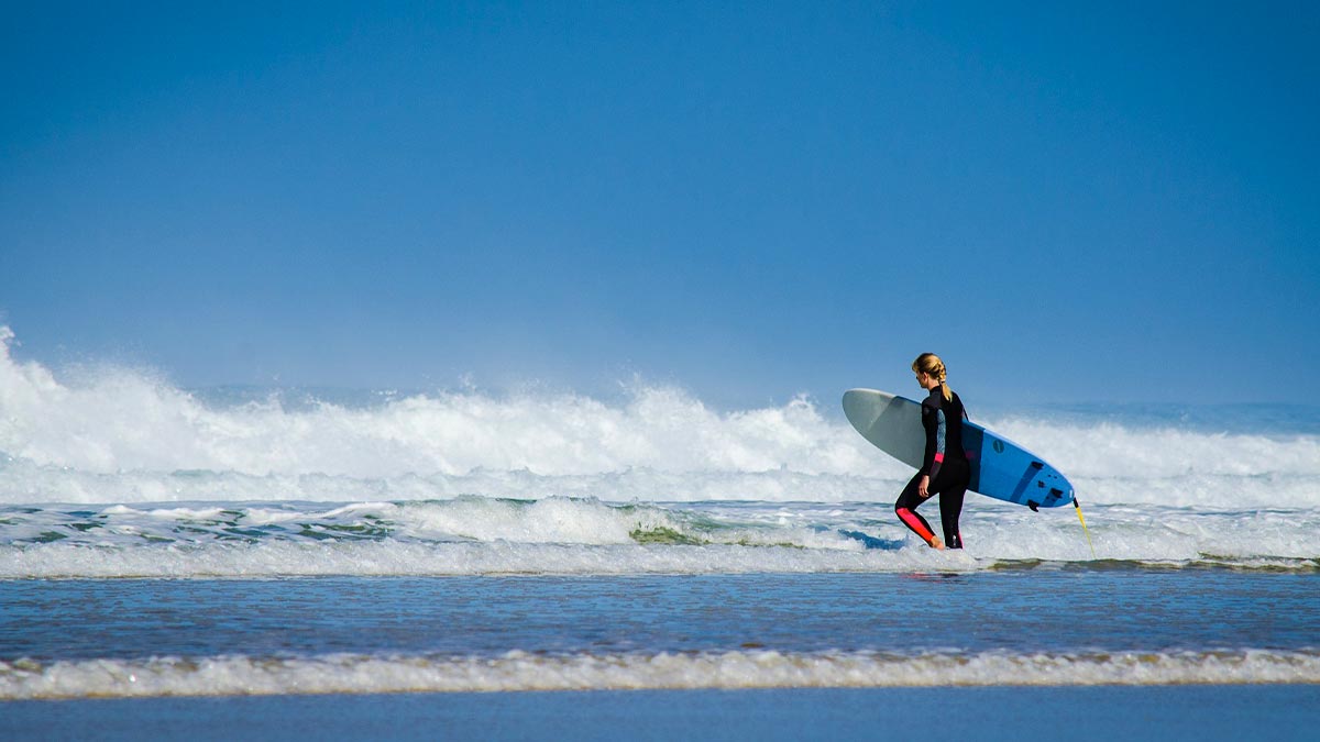 woman surfing with blue surfboard at Pro Surf School in Oahu, Hawaii, USA